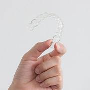 Closeup of patient holding clear aligner