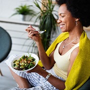 Smiling woman enjoying nutrient-dense meal outside