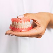 Closeup of person holding dentures in Los Alamitos