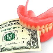 a dollar bill held between a pair of dentures