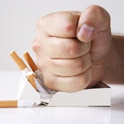 Hand crushing cigarettes to protect dental implants in Los Alamitos