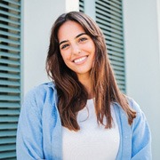 Woman with white teeth smiling while standing outside