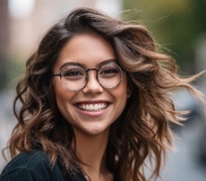 Woman with glasses smiling outside