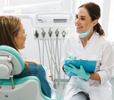 Cosmetic dentist taking notes on clipboard during consultation