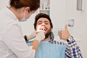man smiling thumb up dentist chair