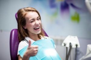 woman giving thumbs up smiling