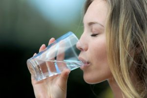 Healthy woman drinks water as recommended by Los Alamitos dentist