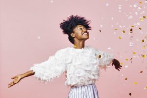 young woman celebrating the new year against a pink background 