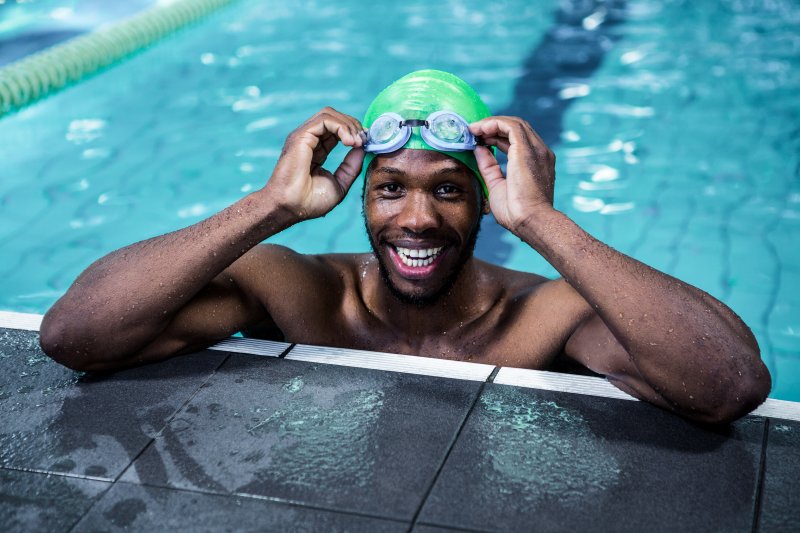 a man smiling while swimming in a pool