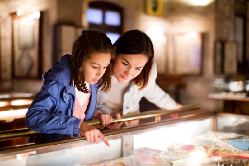 A mother and daughter looking at a teeth whitening exhibit at the museum